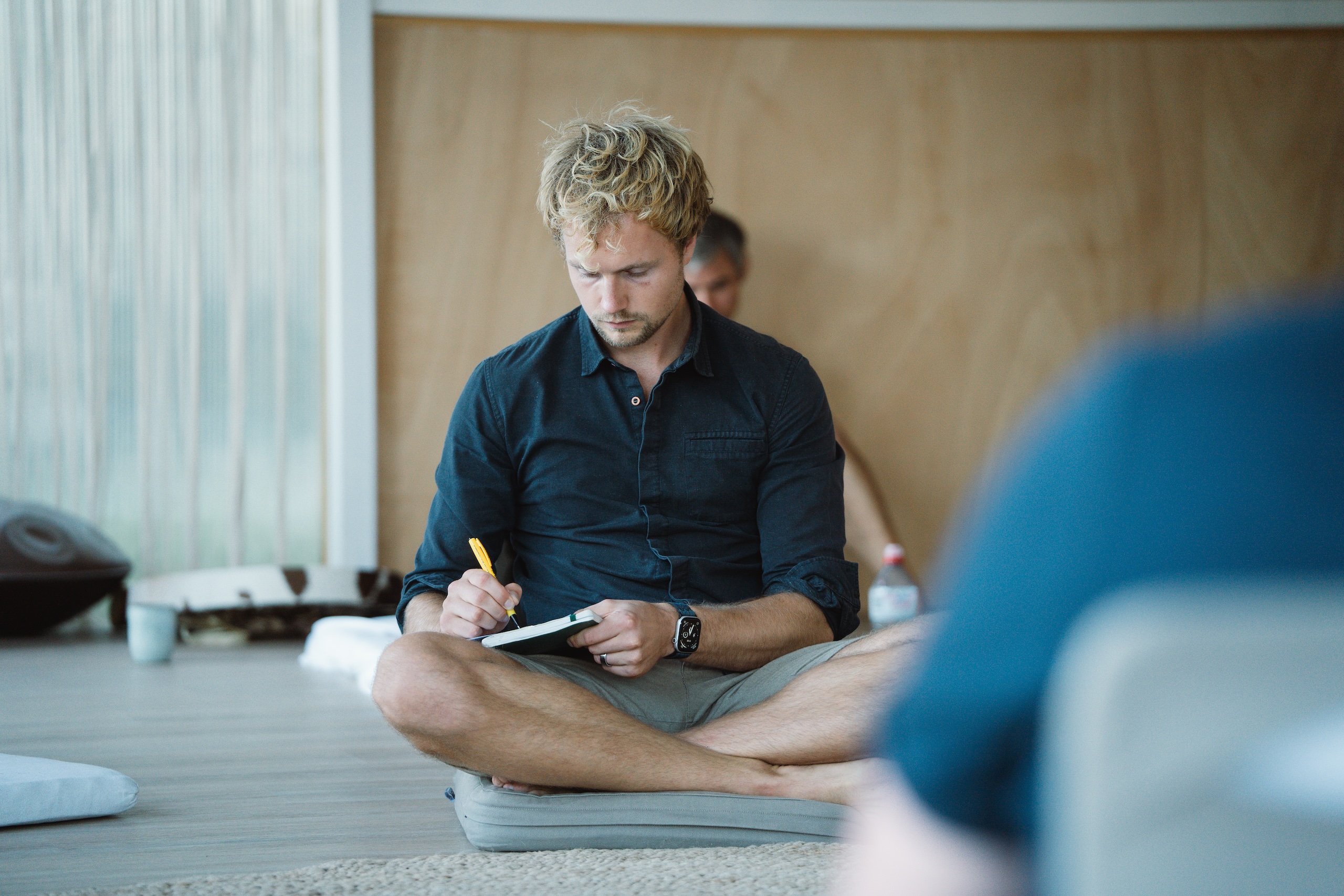 Man schrijft in notitieboek tijdens mannen retreat